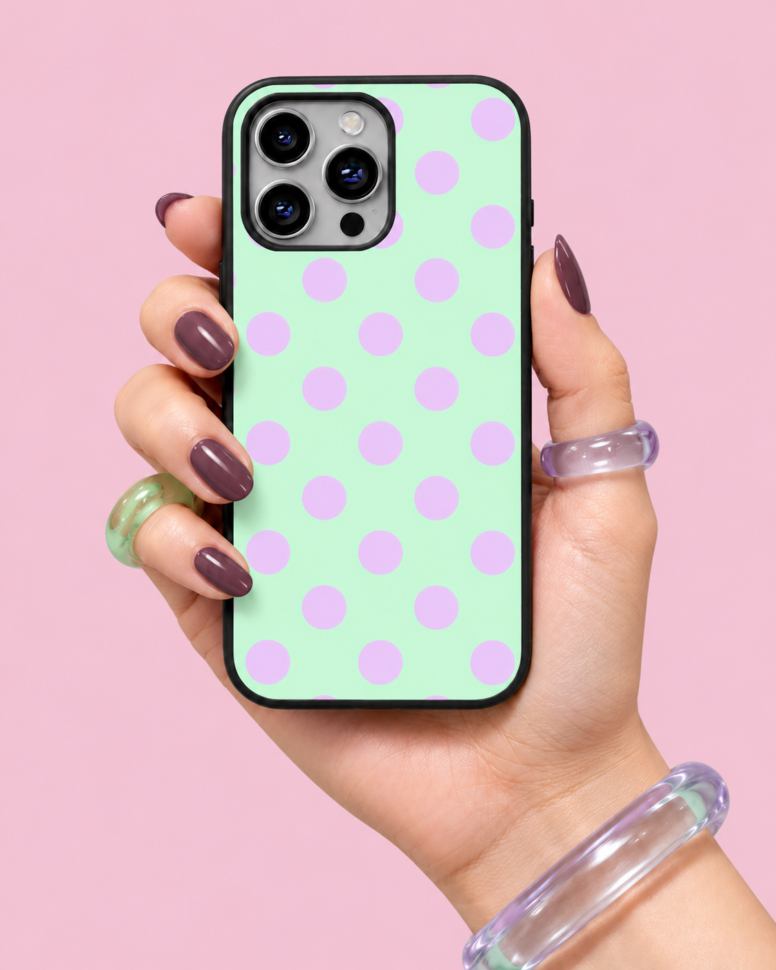 Mint green glass phone case with lilac polka dots held in hand